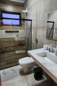 a bathroom with a toilet and a sink and a shower at Casa em Brotas in Brotas