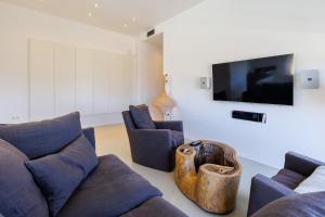 a living room with a couch and chairs and a flat screen tv at Luxury Villa Gialova Lagoon with Private Pool in Gialova
