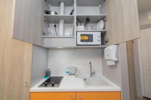 una pequeña cocina con fregadero y microondas en MYFREEDOM Апартаменти метро Шулявська en Kiev
