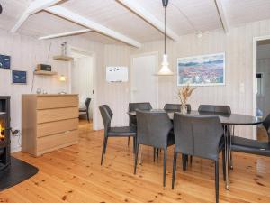 Fjellerupにある8 person holiday home in Glesborgのダイニングルーム(テーブル、椅子、暖炉付)