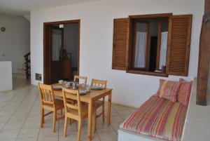 ein Esszimmer mit einem Tisch, Stühlen und einem Bett in der Unterkunft Ca Greta F - Sea View Apartments in Sal Rei
