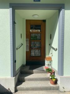 eine Eingangstür eines Hauses mit Treppen und Pflanzen in der Unterkunft Kiki's B&B in Basel