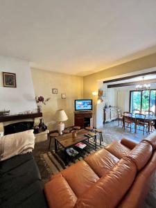 sala de estar con sofá de cuero y mesa en Agréable maison provençale avec jardin en Marsella