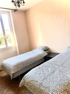 a bedroom with two beds and a window at Agréable maison provençale avec jardin in Marseille