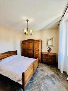 Un dormitorio con una gran cama de madera y una lámpara de araña. en Agréable maison provençale avec jardin en Marsella