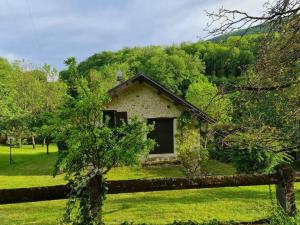 a small stone house in the middle of a field at Maison avec rivière entre Genève et Annecy in Chanay