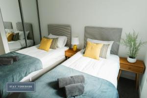 two beds sitting next to each other in a room at Stay Yorkshire IQ 4 Blonk Street in Sheffield