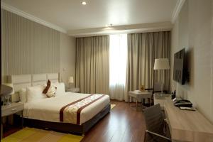 فندق سيتي تاور في الكويت: غرفة في الفندق بها سرير ومكتب ومكتب