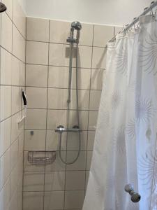 a bathroom with a shower with a shower curtain at Ferielejlighed på Elmensbjerg in Asperup