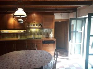 a kitchen with a table with chairs and a sink at Maison avec rivière entre Genève et Annecy in Chanay