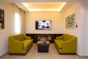 a living room with two yellow chairs and a fireplace at Opera Hotel 