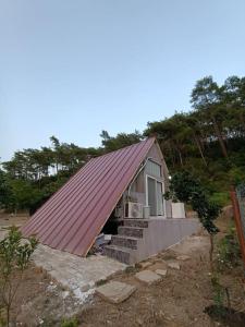 une petite maison avec un toit rouge et des escaliers dans l'établissement Doğa içinde ferah yaşam, à Muğla
