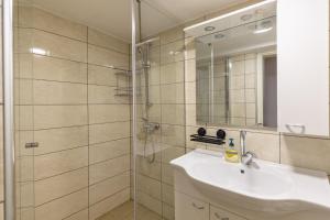 Un baño con lavabo y ducha con espejo. en Apartments Kocjanc, en Bohinj 30 fotos más