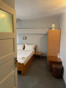 a small bedroom with a bed and a wooden door at Pensiunea Mario in Arad