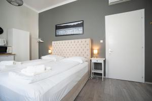 Dormitorio blanco con cama blanca grande y cabecero en Bright ,cozy , central and cute studio in Vienna, en Viena