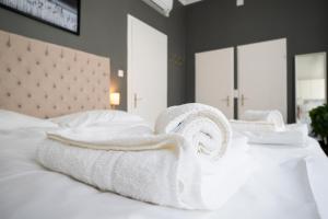 una pila de toallas sentadas encima de una cama en Bright ,cozy , central and cute studio in Vienna, en Viena