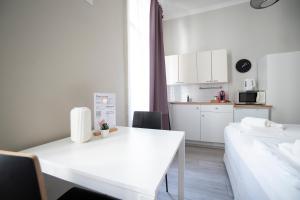Habitación blanca con mesa blanca y cocina en Bright ,cozy , central and cute studio in Vienna, en Viena