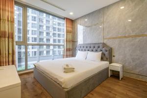 una camera con un letto e una grande finestra di Landmark Vinhomes Christine Apartment ad Ho Chi Minh