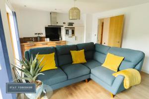 um sofá azul com almofadas amarelas numa sala de estar em Stay Yorkshire IQ 4 Blonk Street em Sheffield