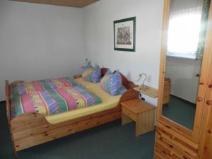 アールベックにあるHaus Eva Mariaのベッドルーム(木製ベッド1台、テーブル付)