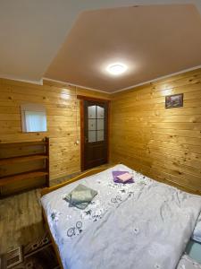 1 dormitorio con 1 cama en una habitación de madera en Файна хата, en Verkhovyna