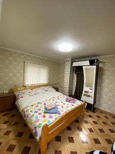 a small bedroom with a bed with a comforter at Файна хата in Verkhovyna