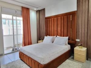 1 dormitorio con 1 cama grande y cabecero de madera en Appartement la gare Rabat ville, en Rabat