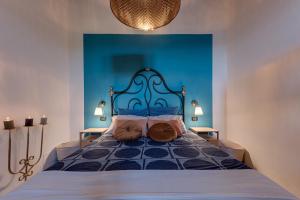 1 dormitorio azul con 1 cama con cabecero azul en Poggio al Mandorlo, en Greve in Chianti