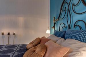 a bedroom with a bed with a blue headboard and pillows at Poggio al Mandorlo in Greve in Chianti