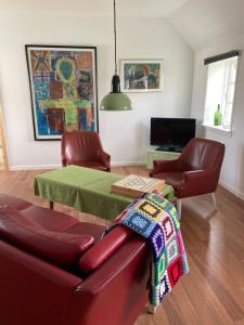 a living room with a couch and a table at Ferielejlighed på Elmensbjerg in Asperup