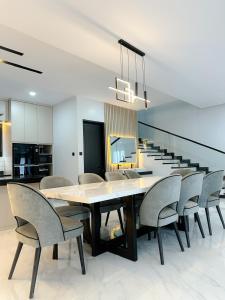 a dining room with a large table and chairs at Villa London Puncak in Sampal 2