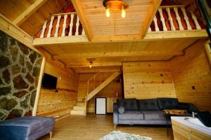 ein Wohnzimmer mit einem Sofa und einem Loft in der Unterkunft PUSLİ DAĞ EVLERİ in Rize
