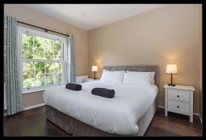 um quarto com uma grande cama branca e uma janela em Stubbs House, Loddon, sleeps 20, 2 hot tubs em Loddon