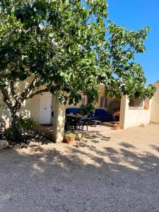 ein Baum vor einem Haus mit einer Terrasse in der Unterkunft 2 bedrooms villa with shared pool enclosed garden and wifi at Turis in Turís