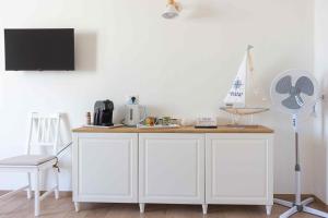 a kitchen with a white cabinet and a fan at Boga & Vopa House in Savelletri di Fasano