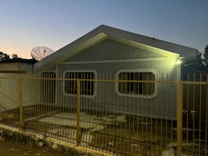 ein Haus mit einem Zaun davor in der Unterkunft Hostel Jotaaa F in Ourinhos