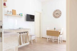 a kitchen with a table and a clock on the wall at Boga & Vopa House in Savelletri di Fasano
