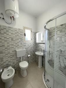 a bathroom with a toilet and a sink and a shower at Vila Relax in Shëngjin