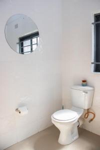 ルサカにあるJRK Apartments & Services Limitedのバスルーム(白いトイレ、鏡付)
