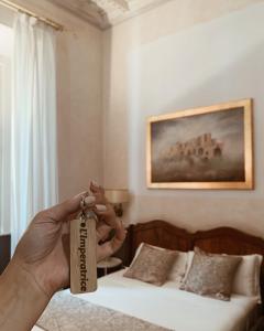 a person holding a tag in a bedroom with a bed at Residenza Sciarra Luxury Guest House in Rome