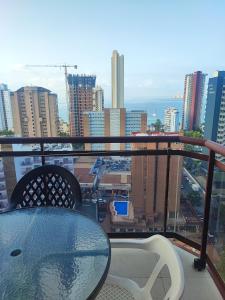 a table and chairs on a balcony with a view of a city at Torremar 17 vistas al mar Benidorm in Benidorm