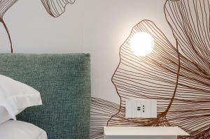 una lámpara en una mesita de noche junto a una cama en Neró Rooms en Taormina