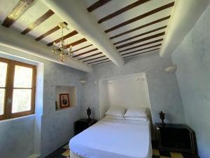 1 dormitorio con cama blanca y ventana en Maison d'hôtes, superbe et spacieuse ,dans un cadre charmant calme et verdoyant, en Pernes-les-Fontaines