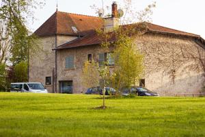 a tree in the grass in front of a building at Aux Ronzières in Pouilly-sous-Charlieu