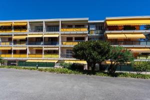 坎城的住宿－C9 2BDR Cannes center AC/Parking easy walk Palais&Sea，公寓大楼设有黄色的阳台和一棵树