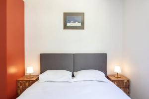 a bedroom with a large bed with two lamps on tables at C9 2BDR Cannes center AC/Parking easy walk Palais&Sea in Cannes