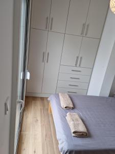 a bedroom with a bed and white cabinets at New house in Pireas port in Piraeus
