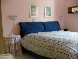 カステル・ディ・サングロにあるCasa vancanze con caminoのベッドルーム(青いベッド1台、テーブル付)