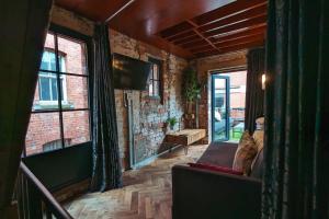 a living room with a couch and a tv and windows at Blayds Yard in Leeds