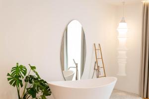 a bathroom with a white tub and a mirror at Neró Rooms in Taormina